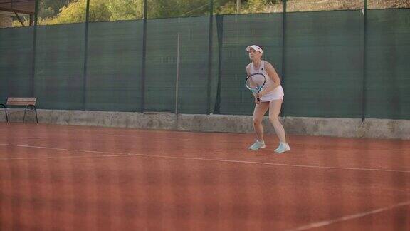 慢镜头:女子职业网球运动员下午在球场上打球