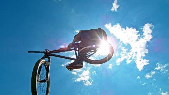 男摩托车手在蓝天的背景下跳跃
