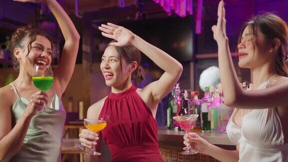 亚洲美女玩得很开心在酒吧餐厅里随着音乐跳舞迷人的年轻女孩朋友感到快乐和放松的聚会喝酒庆祝事件在夜总会
