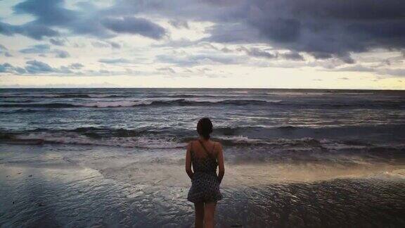 巴厘岛日落时沙滩上的女人