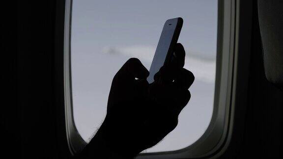 男人在飞机上握着手机使用