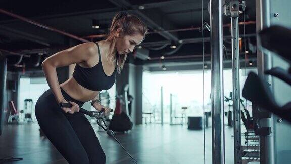 运动的女人在健身房锻炼手臂和肩膀的肌肉健身在健身房锻炼