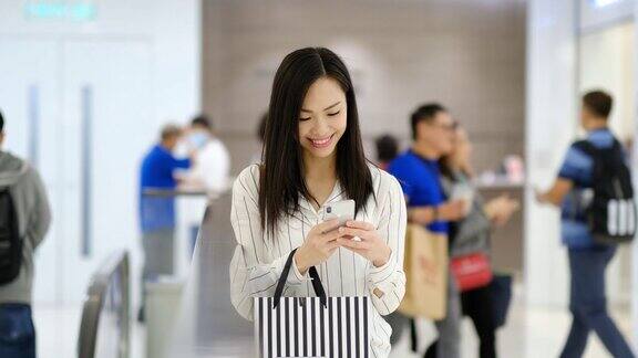 年轻女子在购物中心使用手机