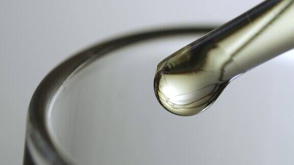 科学家化学家将机油从移液管滴入试管