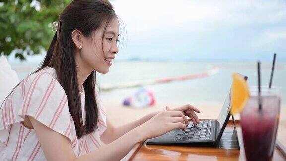 宅度假5G互联网千禧一代亚洲女性穿着泰国亚洲人喜欢在海滩上带着笔记本电脑户外工作