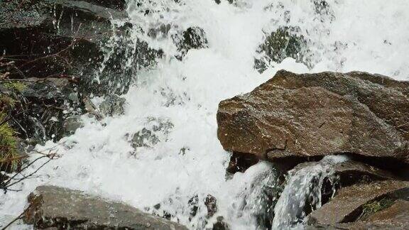 在慢镜头中山涧的水从岩石和巨石上倾泻而下