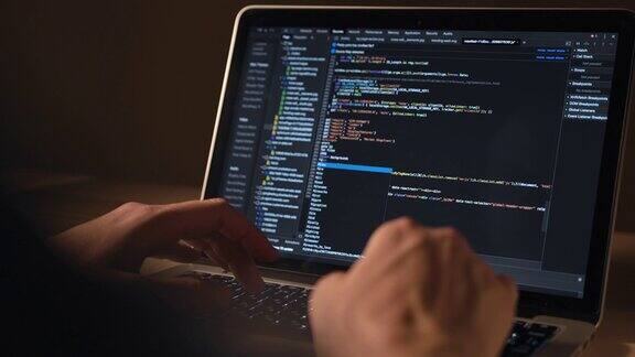 男人的手在笔记本电脑上的编码使用便携式电脑的人程序员编写代码