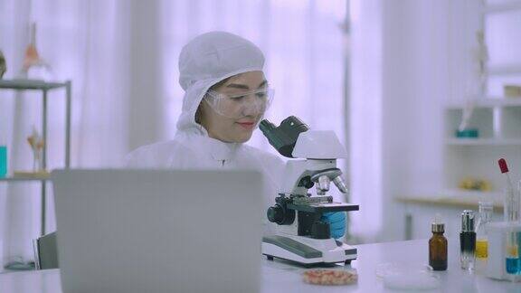 在实验室用显微镜进行科学实验的女科学家