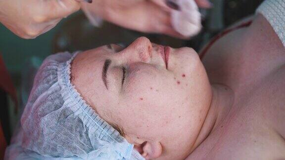 美容师按摩后去除女性脸上的泡沫面膜