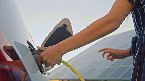 女子在太阳能电动汽车充电站为她的汽车充电