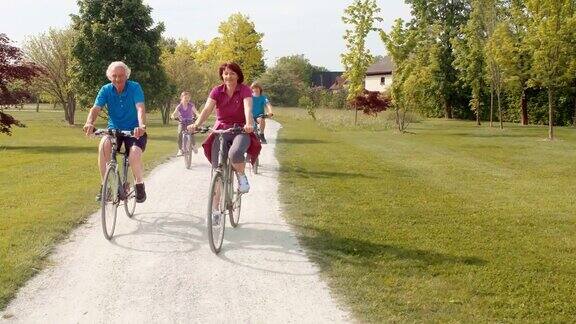 爷爷奶奶和孙辈们在一个阳光明媚的日子里骑着自行车