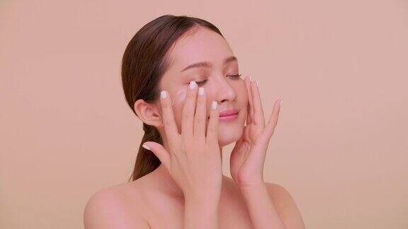 亚洲年轻女性美丽的脸自然的皮肤一个女孩在脸上涂保湿霜的肖像
