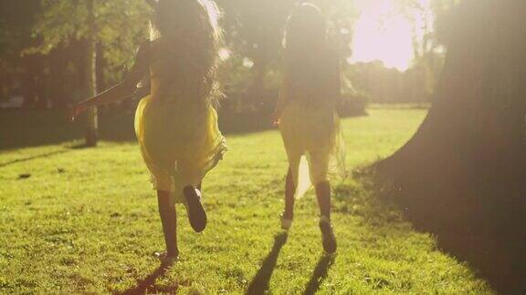 两个女孩在公园的阳光下逃跑