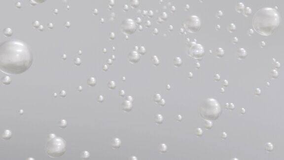 微距离拍摄的各种白色珍珠泡沫在水中上升在灯光背景