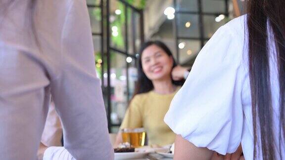 一个亚洲女人在咖啡店和朋友们聊天