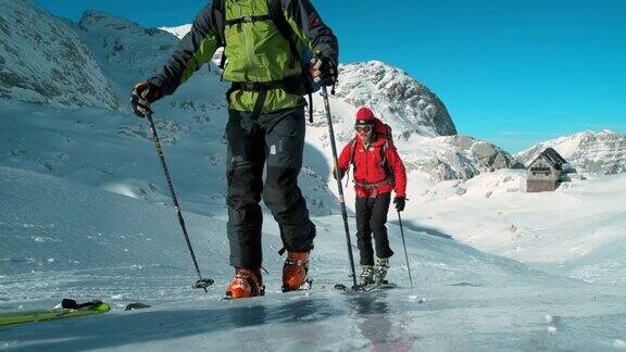 滑雪游客在一个阳光明媚的日子登上结冰的斜坡