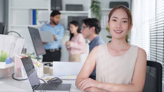 迷人的年轻亚洲女商人的肖像在办公室的办公桌工作空间微笑美丽的女人自信情绪高兴业务工作者