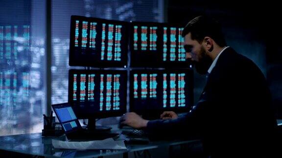 交易员在他的办公桌前开始处理显示在多个显示器上的数字