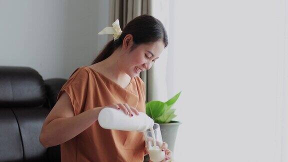 健康年轻的亚洲女性饮用含钙牛奶强健骨骼在家中生活有营养健康的生活