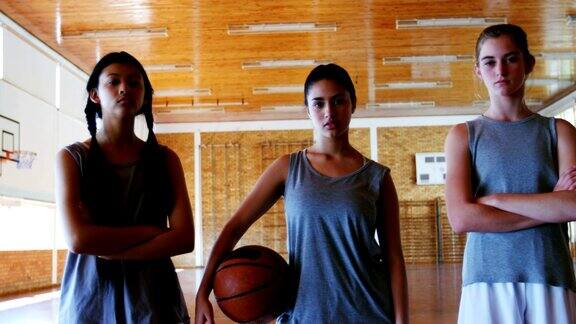 在篮球场上拿着篮球的女学生的肖像