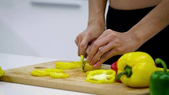 年轻的亚洲运动女性在厨房切蔬菜准备沙拉健康的食物概念