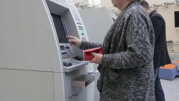 高级女性使用ATM机手持射击