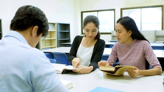 亚洲女学生在图书馆看书聊天