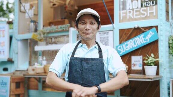 亚洲本地企业主站在他的饮料店前