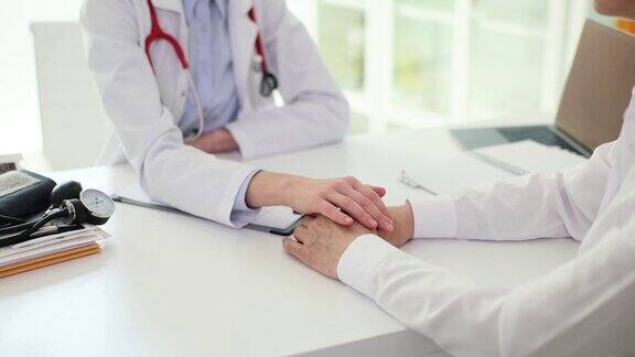 友好的女医生在门诊期间牵着病人的手