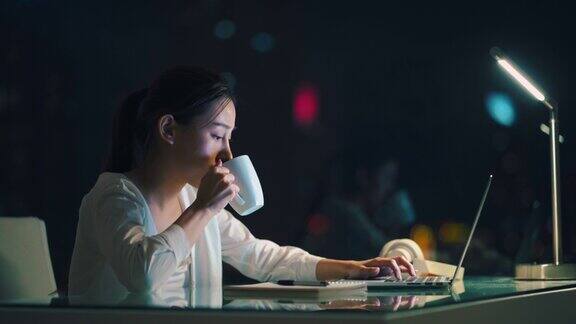 亚洲年轻的女商人在晚上使用笔记本电脑工作