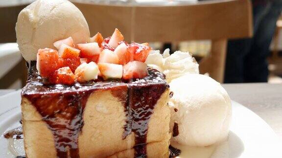 4K:把蜂蜜倒在带冰淇淋和草莓的烤面包上