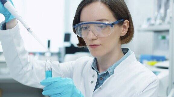 在实验室工作的年轻女科学家的肖像使用微管