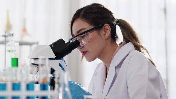 亚洲女性科学家在实验室、显微镜测试和研究中工作