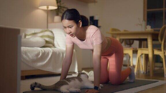 年轻女子在家里的瑜伽垫上锻炼