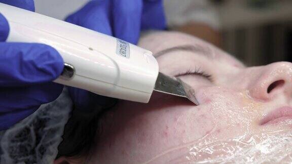 专业美容师使用超声波装置在手上制作程序清洗皮肤年轻女孩与痤疮皮肤在现代美容诊所概念美医疗诊所