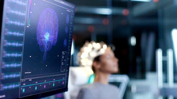 现代大脑研究实验室神经研究中心一名戴着脑电波扫描耳机的女性坐在椅子上监视器显示脑电图读取和大脑模型
