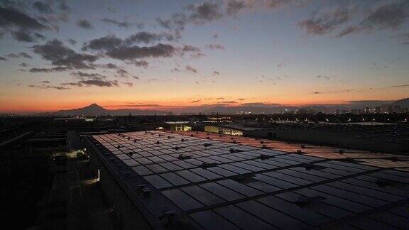 黄昏鸟瞰工厂屋顶上有太阳能电池板