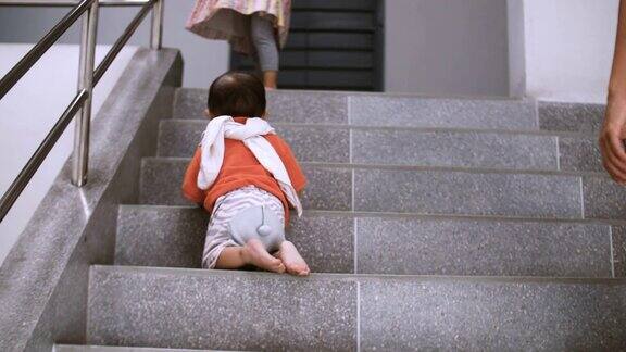 蹒跚学步的婴儿在家里“第一步”爬楼梯