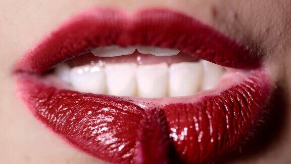 女人的嘴用刷子涂着红色的口红