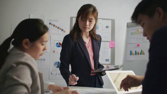 会议上亚洲女商人向同事们做详细的业务介绍