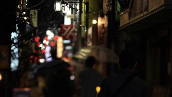 在东京中野的雨天在繁华的霓虹街上行走的人们