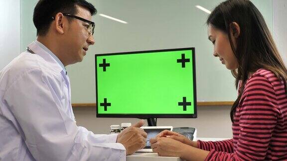 医生与病人在绿屏电脑上讨论结果