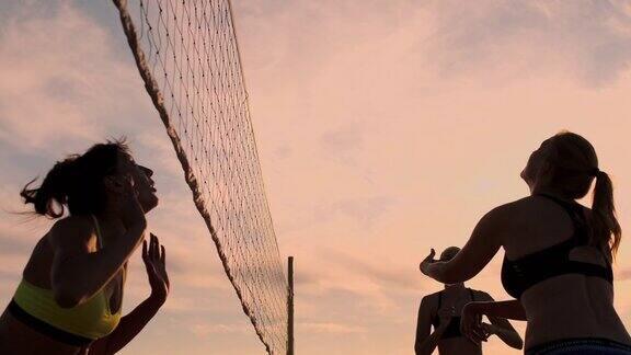 一群年轻女孩在日落或日出时打沙滩排球慢镜头