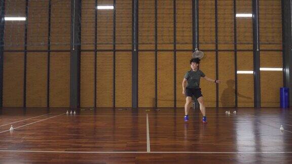 广角亚洲中国羽毛球运动员在羽毛球场上进行耐力训练