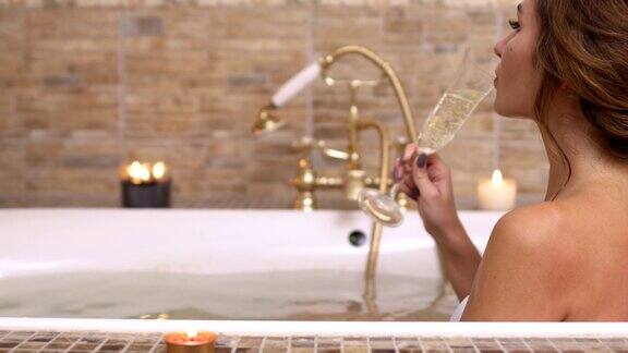 美女喝着香槟享受着洗热水澡的乐趣