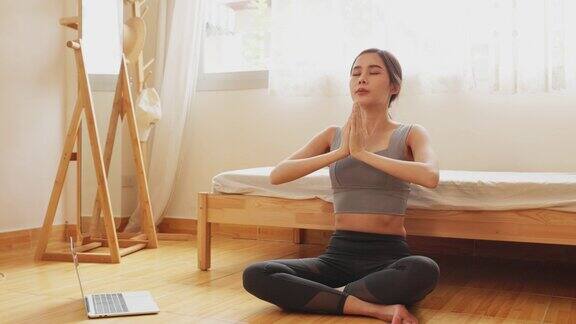 美女在床上醒来她在练瑜伽年轻女子在家卧室练习瑜伽
