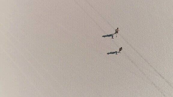 一对夫妇在沙漠中跑步的鸟瞰图