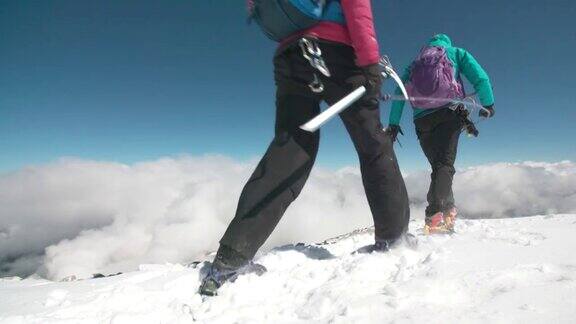 两名女性登山运动员在冰川上穿越山脊