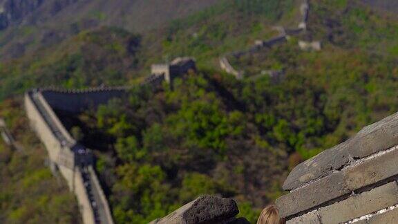 一个年轻的女人透过中国长城的开口处这座墙在山的一侧开始倒塌