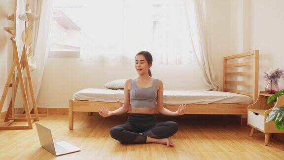 美女在床上醒来她在练瑜伽年轻女子在家卧室练习瑜伽